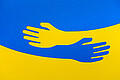Ukrainische Flagge mit blauer und gelber Hand: Der Evangelische Kirchenkreis Aachen bietet Unterstützung für die Opfer des Krieges in der Ukraine an.